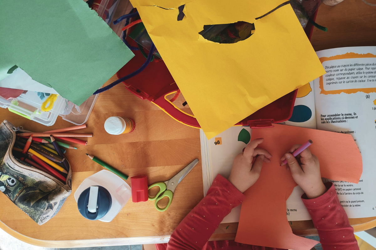 Colorful crafting materials like scissors, paper, glue, and markers on a home desk for fun DIY projects