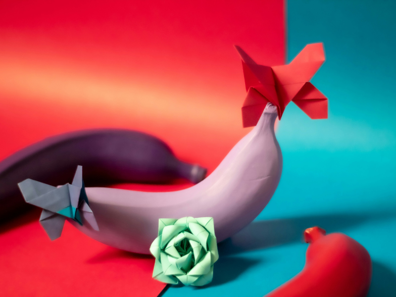 Origami paper animals and colorful folded paper flowers on a wooden table