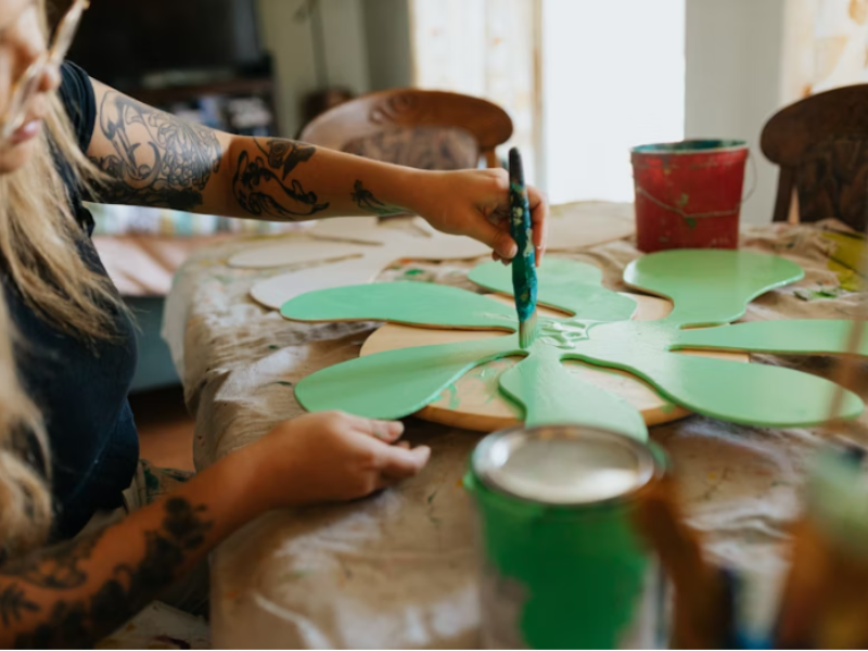 Watercolor painting in progress with paintbrushes and color palette on a table