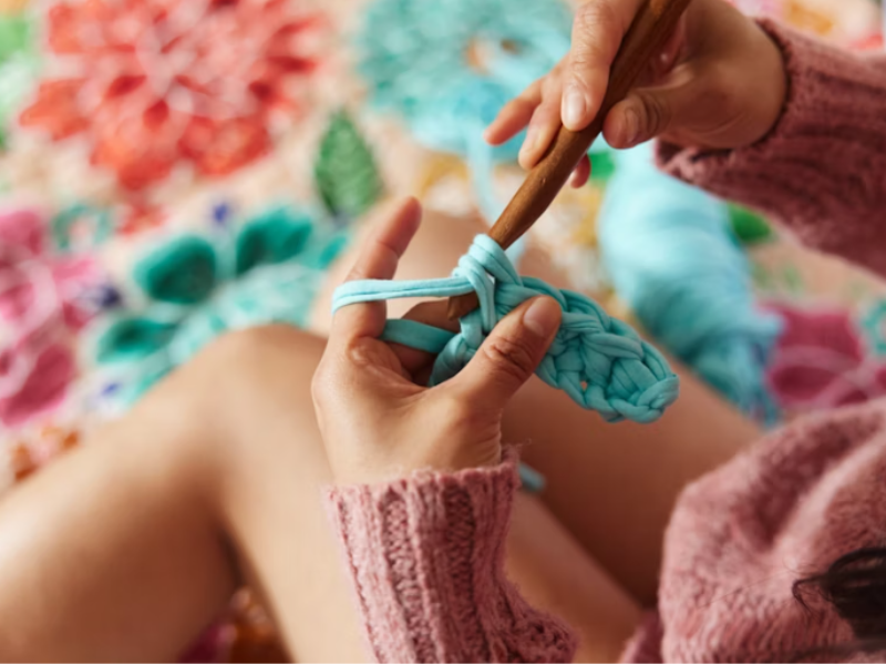 DIY yarn pom-poms and tassels arranged on a table with scissors and glue